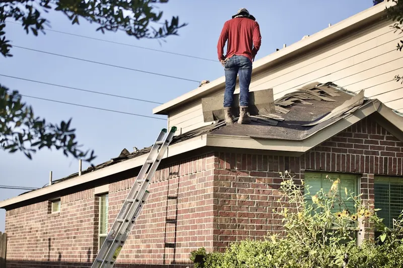 Professional roofer working on a residential roof in Bemiss